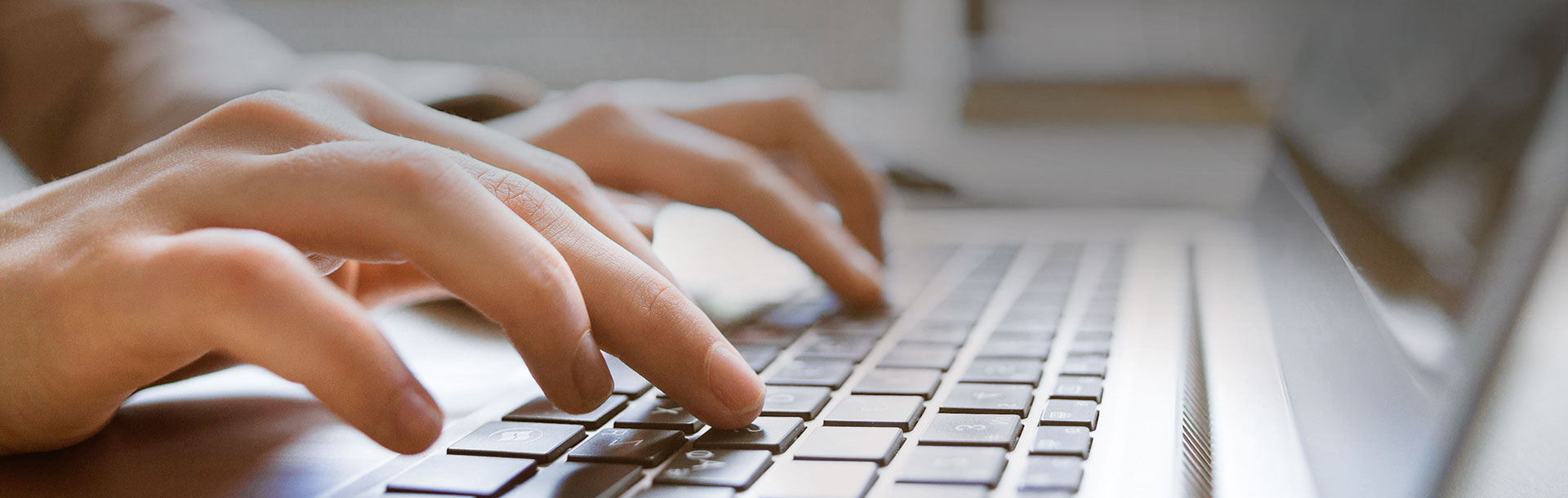 Las manos de una persona escribiendo en un teclado de una computadora