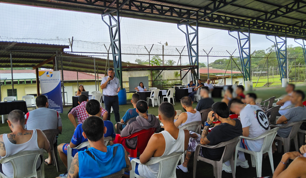Mujer dando la mano a otra persona frente a unas rejas